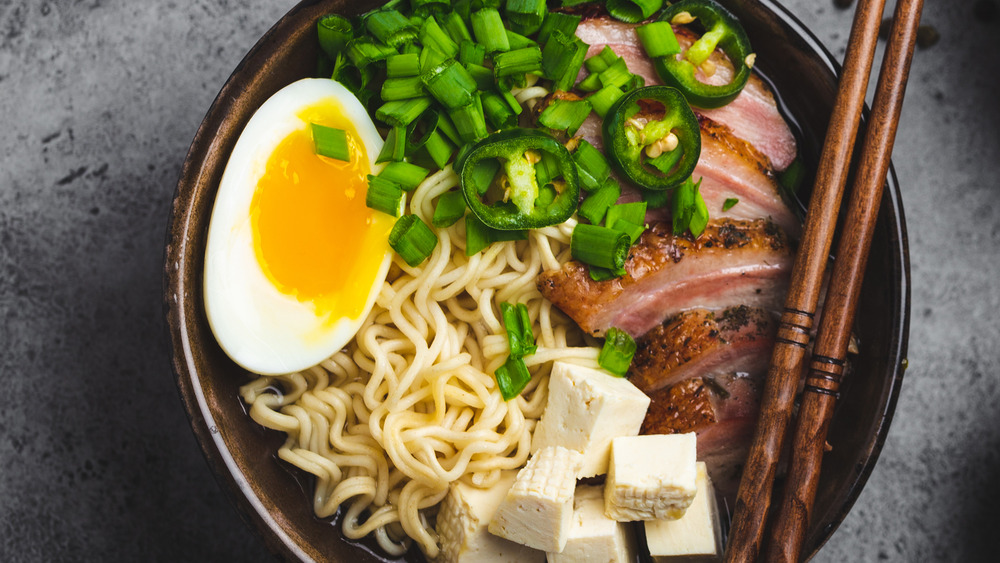 bowl of ramen with eggs, meat, and scallions