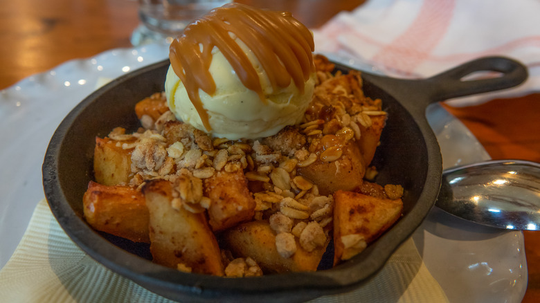 An apple skillet cookie with ice cream and caramel