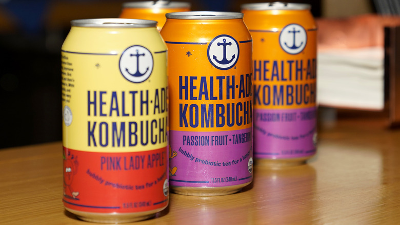 Three Health-Ade Kombucha cans