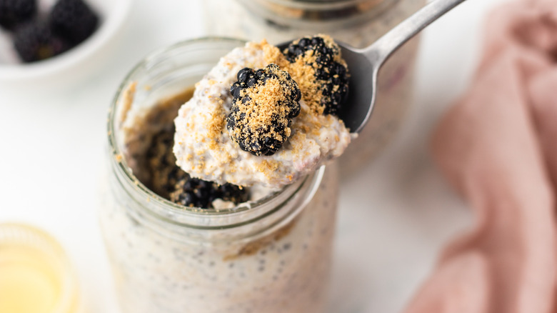 spooning blackberry overnight oats out of jar