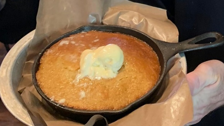 sweet cornbread in cast iron skillet with honey butter