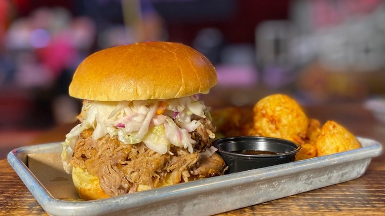 pulled pork sandwich with barbecue sauce and tots