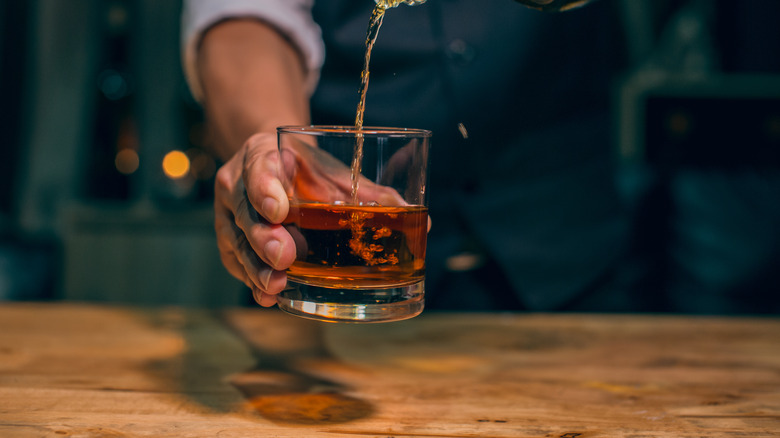 whiskey being poured into cup