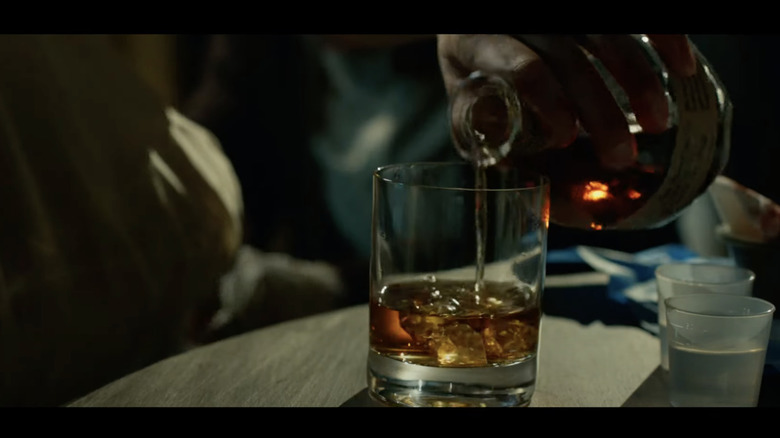 bottle of bourbon being poured into cup