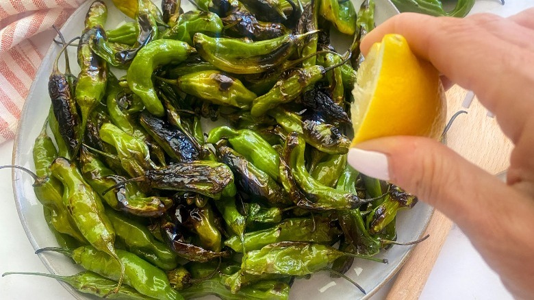 squeezing lemon juice on peppers