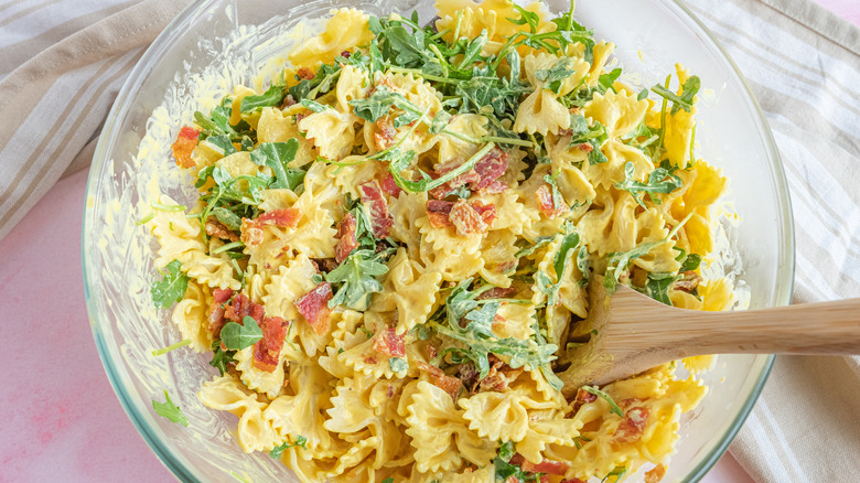 stirring dressing into pasta salad