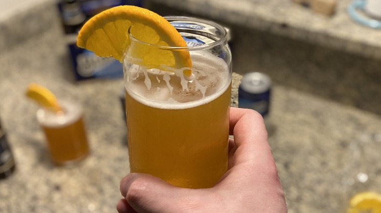 Hand holding non-alcoholic Blue Moon