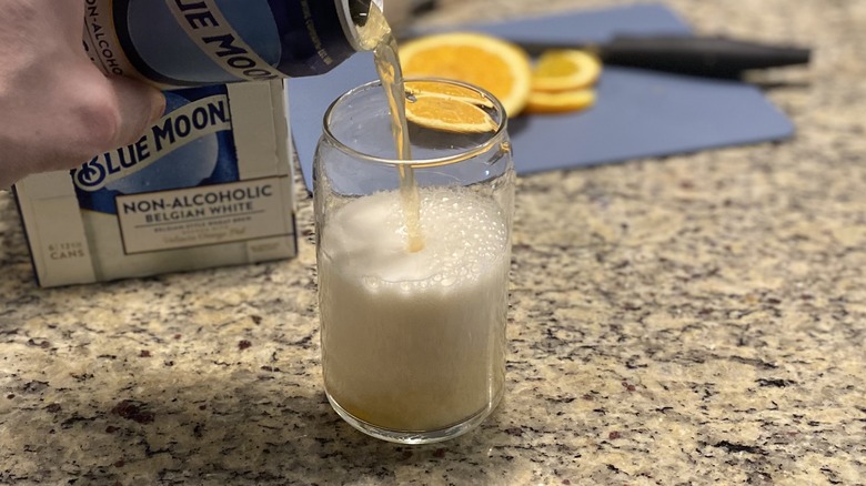 Person pouring non-alcoholic Blue Moon