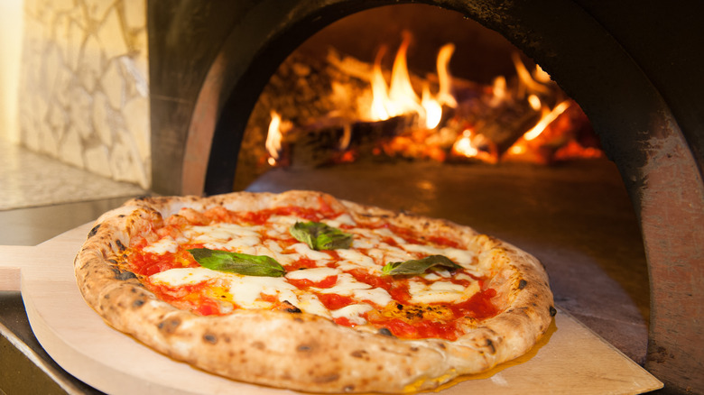 Pizza being removed from a pizza oven