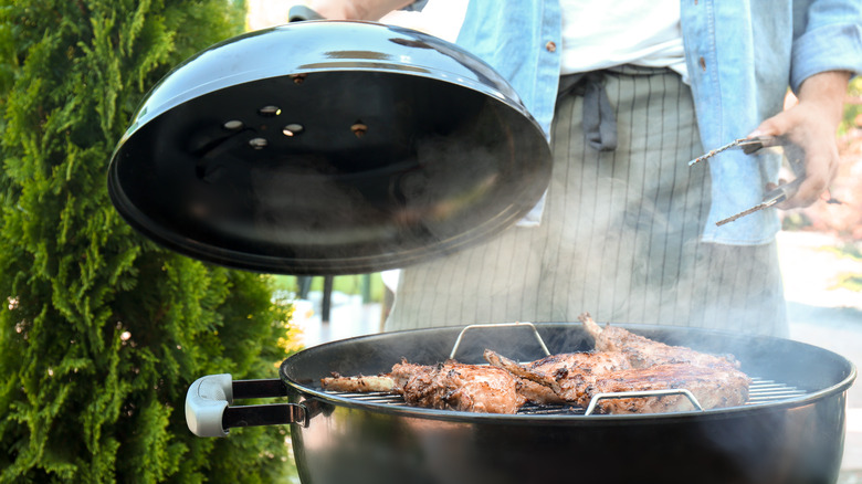 Man putting lid on the grill