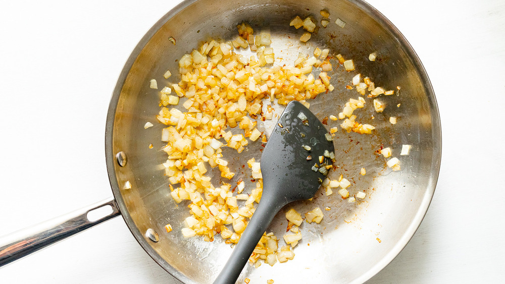 Sauteing onions in pan for Bobby Flay's shrimp and grits with a twist