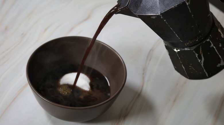 pouring coffee into bowl with sugar