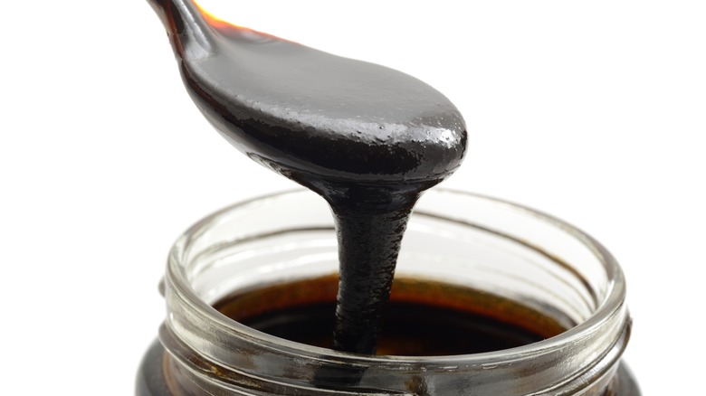 Spoonful of dark molasses in jar