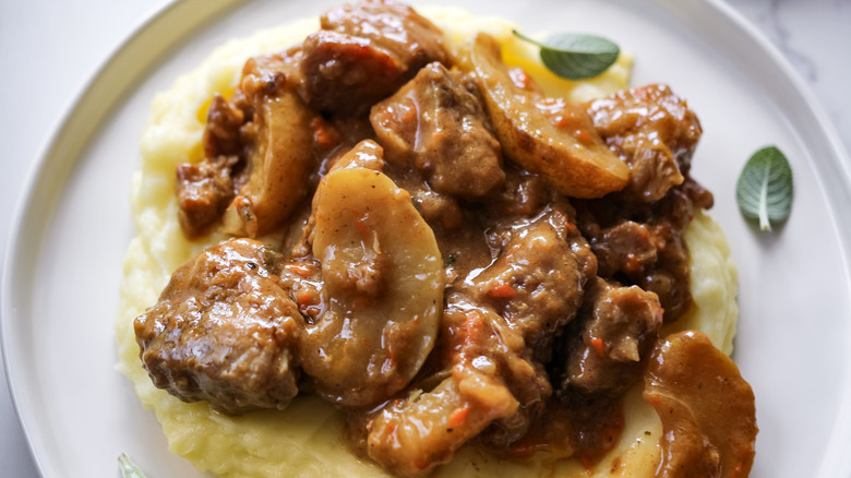 braised pork and apple casserole over mashed potatoes