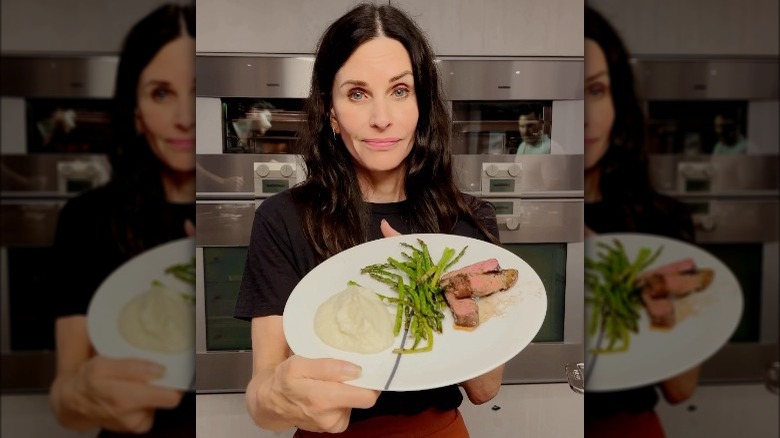 Courteney Cox holding a plate of food