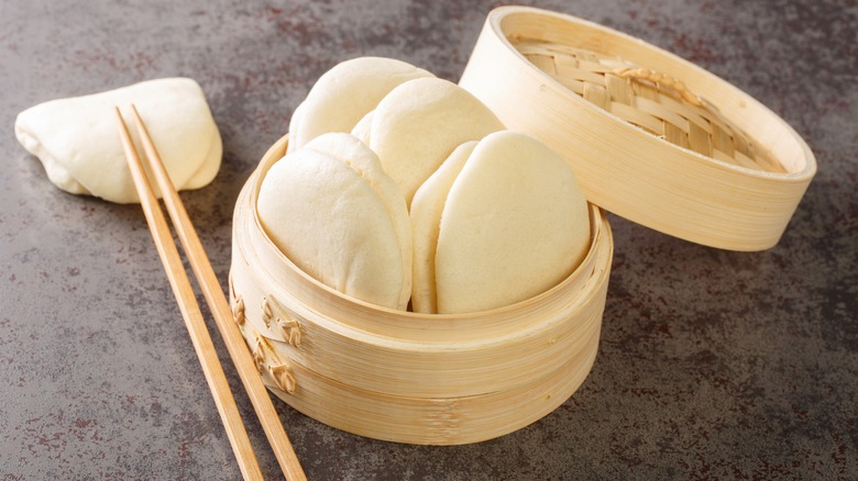 Bao buns in wooden container with chopsticks