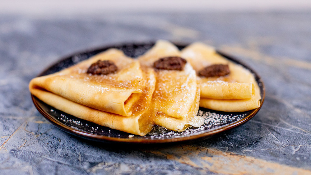 plate of crepes with powdered sugar