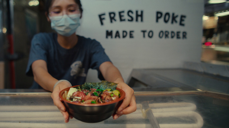 A bowl of poke being served