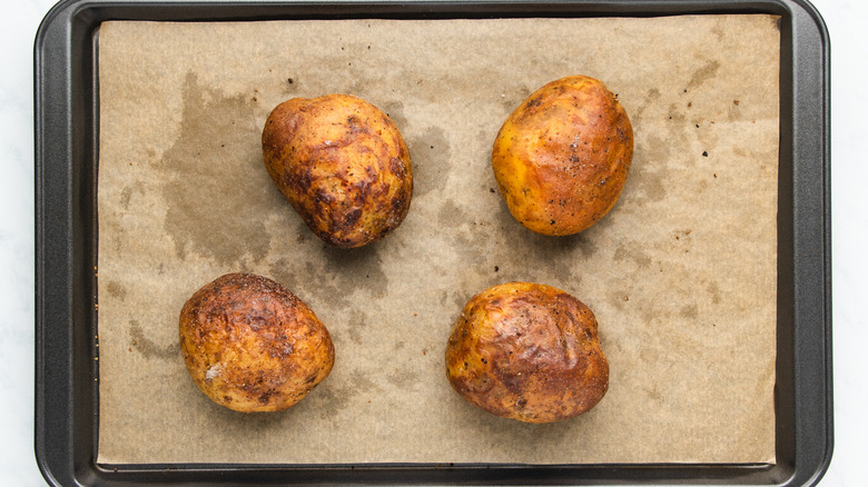 Baked potatoes on baking sheet