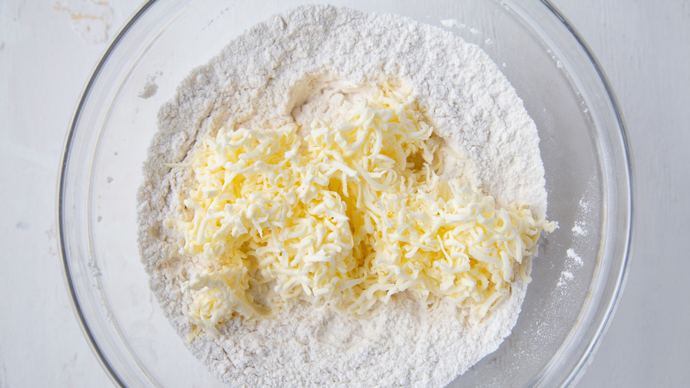 grated butter and flour in glass bowl