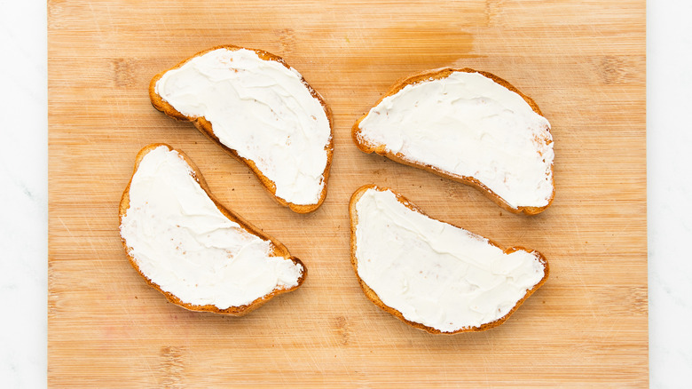 toasts with cream cheese on cutting board