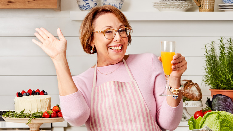 Babs in kitchen holding drink