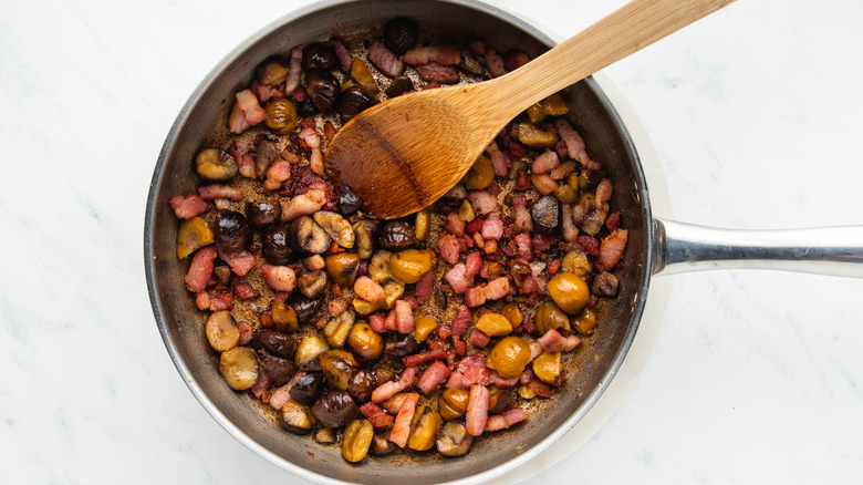 Bacon and chestnuts frying in pan