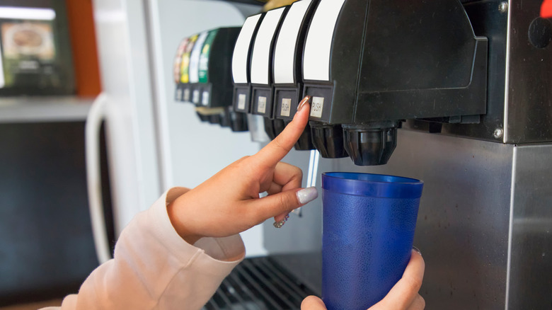 filling blue cup from soda fountain