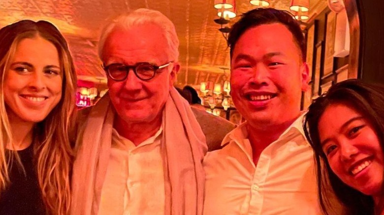 Buddha Lo and Alain Ducasse smiling with friends