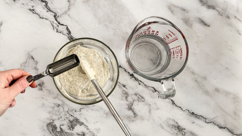 hand stirring yogurt dressing