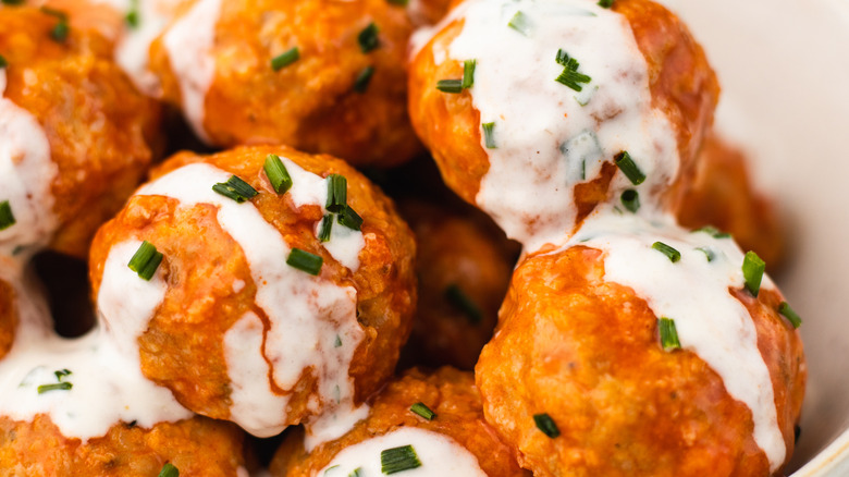 Close up of buffalo chicken meatballs with ranch sauce