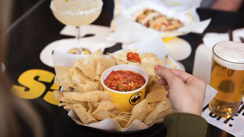 Scooping salsa with tortilla chips