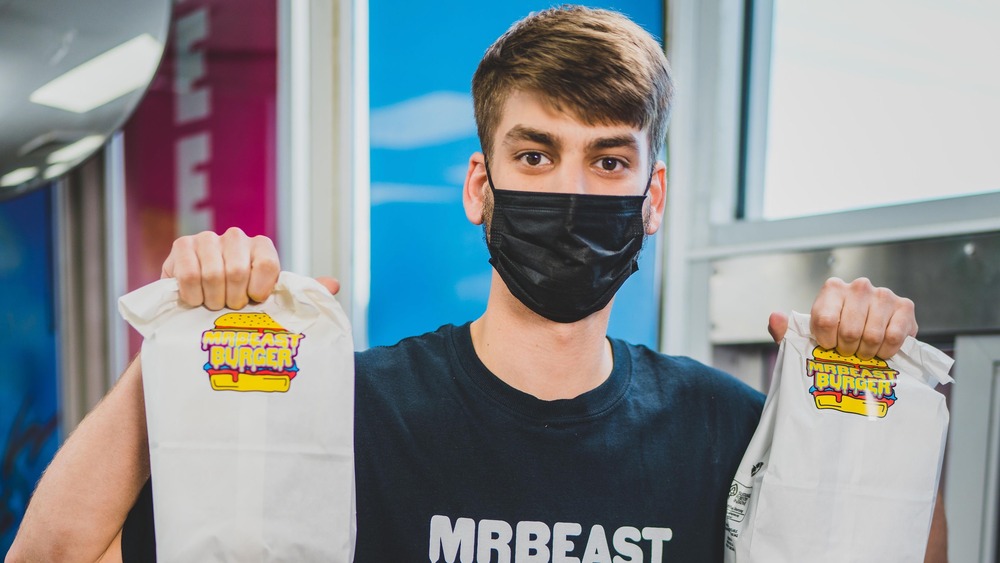 Man holding Mr. Beast Burger bags