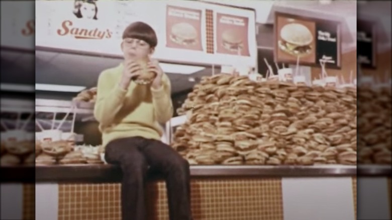 Boy eating Sandy's burger