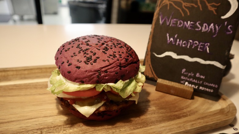 Whopper with purple bun on wooden board