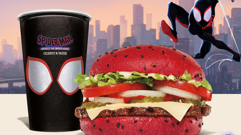 Spider-Man cup next to burger with red bun 