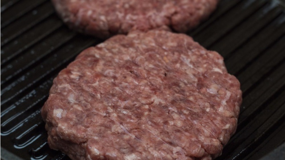 Cooking burger patties on a cast iron pan