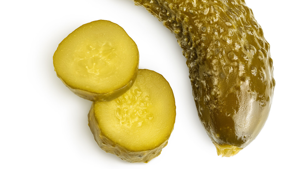 Two pickles on white background