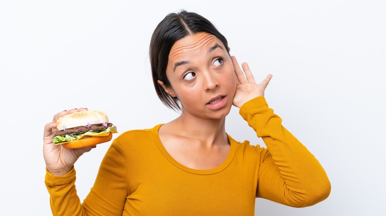 girl with burger listening