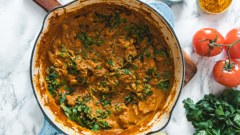 butter chicken in pan with cilantro