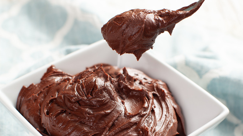 spoon scooping chocolate buttercream frosting