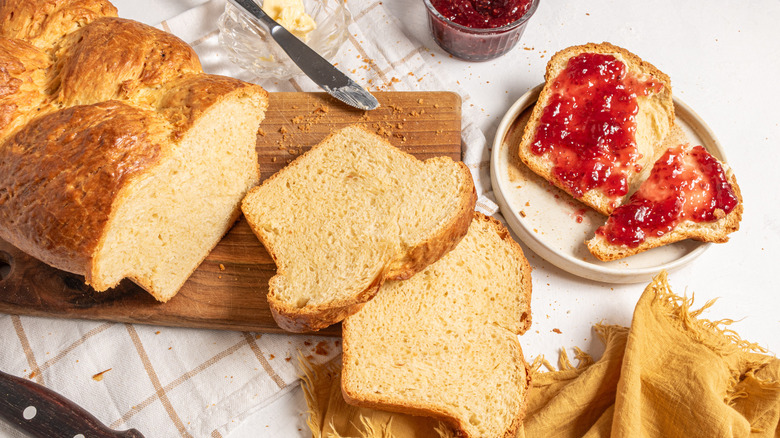 Brioche bread with two slices and one on a plate with jam on top