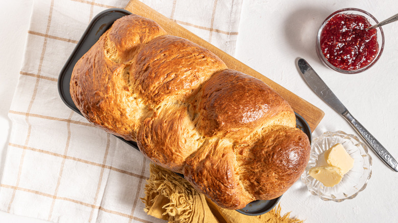 Brioche bread insede a baking dish with a side of jam and butter