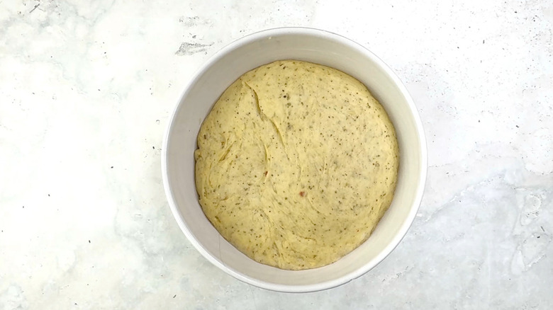 risen bread dough ball in mixing bowl