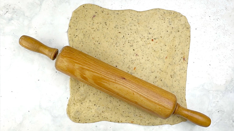 rolling pin over sheet of bread dough