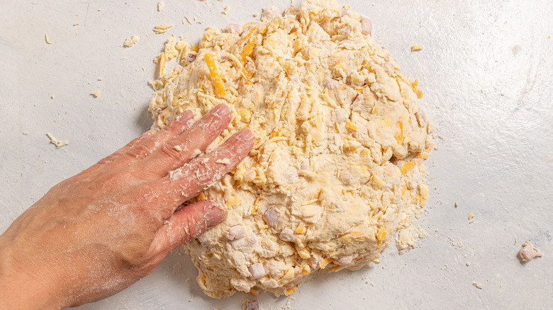 Shaping а dough with cheese and ham in it