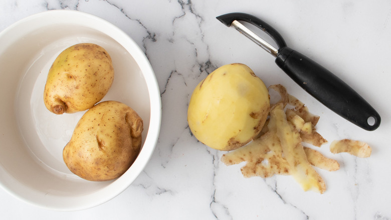 peeling potatoes with peeler