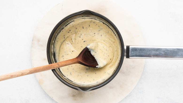 Mixing Alfredo sauce in pan