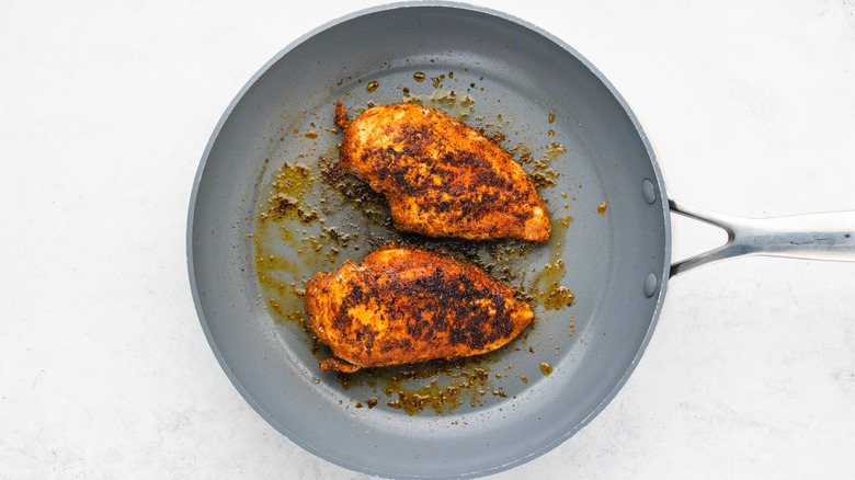 Chicken breasts frying in pan