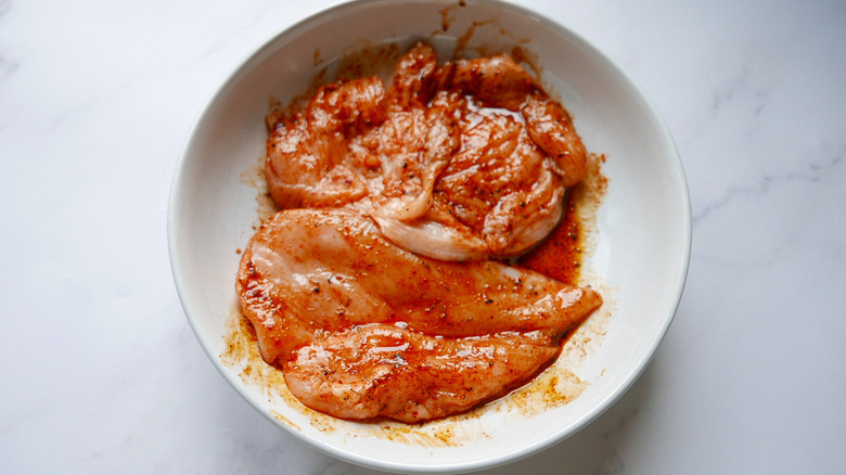 Chicken marinating in Cajun spice